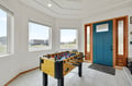 Challenge friends to foosball in your bright entryway, where the turquoise door welcomes you home after beach adventures.