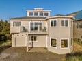 Modern coastal home with spacious decks and panoramic windows, perfectly positioned among the dunes for your seaside escape.
