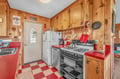 Your charming rustic kitchen features warm knotty pine cabinets, vibrant red countertops, and all the essentials for cozy meal prep.