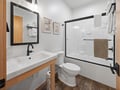 Step into your sleek bathroom with modern fixtures, spacious shower, and warm wood accents that create the perfect blend of style and comfort.
