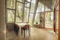 Dine surrounded by nature in this light-filled space where floor-to-ceiling windows frame the forest beyond your table.