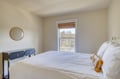 Step into your peaceful bedroom retreat, where crisp linens and natural light create a serene space for restful nights. The window frames lovely neighborhood views to greet you each morning.