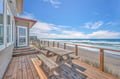 Beachfront property offers expansive deck with direct ocean access and panoramic coastal views.