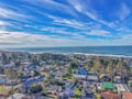 Stunning aerial view of a charming coastal neighborhood stretching toward the Pacific Ocean with pristine beaches nearby.