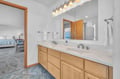 Your spacious ensuite bathroom features dual vanity sinks, perfect for sharing morning routines while enjoying fresh linens.