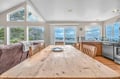 Your coastal dining space overlooks breathtaking water views through floor-to-ceiling windows, where shared meals become unforgettable moments.
