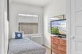 Relax in your cozy bedroom with a large TV for movie nights and coastal artwork that brings beachside charm to your stay.