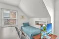 Curl up in your cozy bedroom nook with slanted ceilings and natural light streaming through the window.