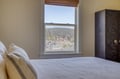 Wake to serene forest views framed by your bedroom window, where peaceful mornings greet you with layered tree lines and neighboring rooftops nestled in nature's embrace.