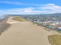 Expansive coastline with pristine sandy beaches stretches alongside a charming seaside town, offering miles of oceanfront relaxation.