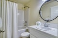 Clean and well-appointed bathroom with tub-shower combo, elegant mirror, and fresh towels ready for your stay.