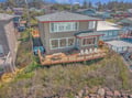 Coastal retreat featuring spacious deck with outdoor seating overlooking beachfront community and natural dunes.