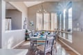 Gather around this bright dining space where morning sunlight streams through tall windows, creating the perfect setting for memorable meals together.