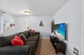 Unwind on the plush sectional sofa while watching your favorite shows on the large smart TV in this cozy living space.