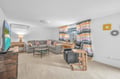 Sink into plush sofas and enjoy movie nights on the large TV in your bright, modern living space with colorful accents.