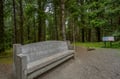 Dense forest trail with carved wooden bench and interpretive signage creates peaceful natural setting near the property.