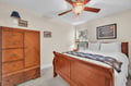 Rest comfortably in your charming bedroom featuring beautiful wood furniture and crisp linens, complete with ceiling fan for gentle airflow.