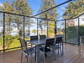 Dine al fresco on your private deck with stunning lake views through elegant glass panels.