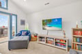 Unwind in your bright living space with plush seating, tropical beach views on the big screen, and shelves stocked with books and games for cozy evenings in.
