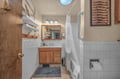Your cozy bathroom features nautical charm with fresh white subway tile, warm wood accents, and modern fixtures. Crisp towels and thoughtful lighting create a welcoming retreat after your day's adventures.