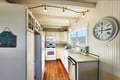 Step into your fully equipped kitchen with warm hardwood floors, classic white cabinetry, and everything you need to prepare meals. The bright window floods the space with natural light, while charming coastal touches add personality.