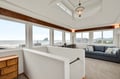 Sink into your comfortable sofa and soak in stunning ocean views through floor-to-ceiling windows in this bright, airy living space.