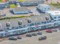 Aerial view of the charming seaside property with distinctive dormer windows and convenient street-level parking for easy arrival.