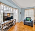 Settle into your inviting living room, where natural light spills through tall windows and calming blue walls create a peaceful retreat for unwinding after exploring.