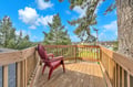 Step onto your private deck where red chairs await under towering trees, offering peaceful moments with neighborhood views.