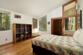 Wake up surrounded by forest views in this serene bedroom, where warm wood tones and modern comfort create your perfect retreat.