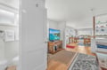 Step into your bright, open living space where warm hardwood floors and coastal charm create the perfect retreat for relaxation.
