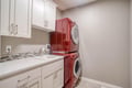Your laundry days just got easier with this dedicated space featuring stylish red appliances, plenty of storage, and a convenient sink.