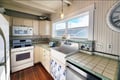Your fully-equipped coastal kitchen invites you to cook with charm—tile countertops, vintage details, and natural light streaming through the window create a relaxing, homey feel.