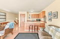 Relax in your open-concept living area with cozy seating, a welcoming kitchen, and warm wood finishes that make you feel right at home.