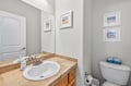Your private powder room features a stone vanity and coastal artwork, perfect for freshening up during your stay.