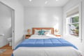 Sink into this serene bedroom where sunlight streams through your window, highlighting crisp linens and coastal-blue accents that promise restful nights.