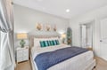 Sink into this serene bedroom where soft coastal hues and plush linens create your perfect retreat.