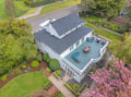 Stunning aerial view of this beautiful property featuring a spacious rooftop deck with swimming pool, surrounded by lush landscaping and gardens.