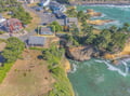 Coastal property aerial view showcasing the dramatic oceanfront location with rugged cliffs and pristine waters nearby.