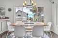 Gather around your bright dining table where warm lighting meets modern style, perfect for morning coffee or evening meals together.