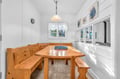 Cozy corner dining nook where you'll enjoy morning coffee and meals in warm sunlight streaming through charming windows.