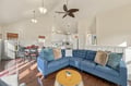 Sink into the plush blue sectional sofa and let the warm sunlight wash over this breezy, open living space—your cozy coastal retreat awaits.