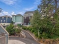Your coastal retreat is nestled among charming beach homes in a quiet neighborhood, just steps from the shore. A private driveway winds gently to your door, surrounded by lush greenery and coastal breezes.
