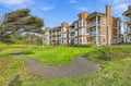 This coastal property features well-maintained grounds with mature landscaping and walking paths, offering easy access to the area's natural beauty and surrounding amenities.