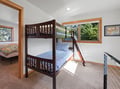 Sunlight streams through your window onto cozy bunk beds with cheerful blue linens, perfect for families or friends sharing adventures.