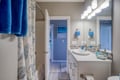 Refresh in your beautifully appointed bathroom with coastal charm, featuring modern fixtures and soothing blue accents.