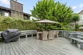Spacious deck with dining table, umbrella shade, and BBQ