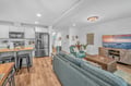 Your open-concept retreat seamlessly blends modern kitchen and cozy living space, perfect for relaxing after beach adventures.
