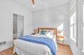 Drift off in your bright bedroom where coastal blues meet warm wood tones, creating the perfect peaceful retreat.