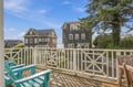Relax on your private deck overlooking charming coastal homes and towering trees, where morning coffee and sunset evenings feel like a true escape.